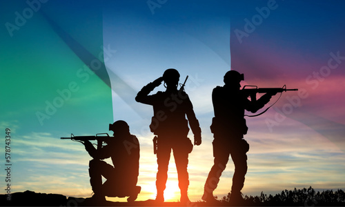 Silhouettes of a soldiers with Italian flag against the sunset. Armed Forces of Italy. EPS10 vector photo