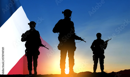 Silhouettes of French soldiers on background of sunset and French flag. Concept - Armed Forces. EPS10 vector