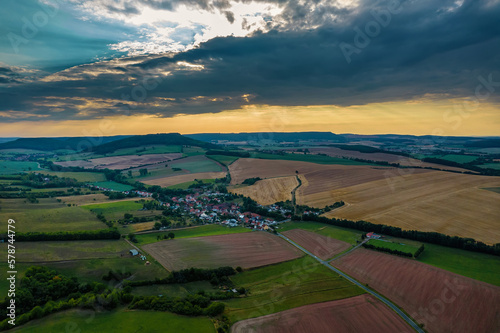 Aer ial view of a German village surrounded by meadows, farmland and forest in Germany. © Igor Syrbu