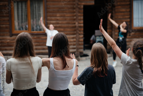 Kids have fun in the summer camp with hands up from back