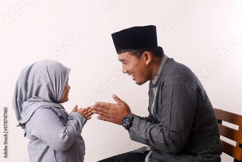 Muslim family and kid greeting and asking forgiveness shaking hand on ramadan and eid mubarak