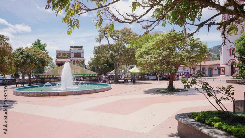 Guatapé town and nice colonial park with water fountain, trees and colorful houses in Colombia in South America in the Andes mountains.