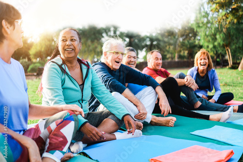 Fotografia Happy senior people after yoga sport class having fun sitting outdoors in park c