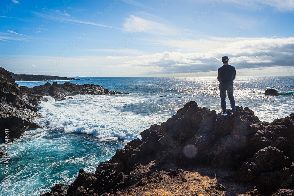 Ein Mann schaut in der Nähe von El Golfo auf Lanzarote auf den stürmischen Atlantik 