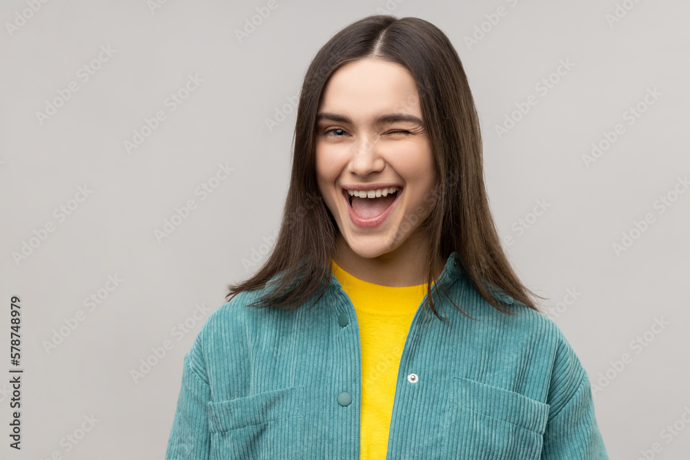 Cheerful woman winking eye and flirting with someone, looks at camera, expressing happiness. Cheerful woman winking eye and flirting with someone, looks at camera, expressing happiness.