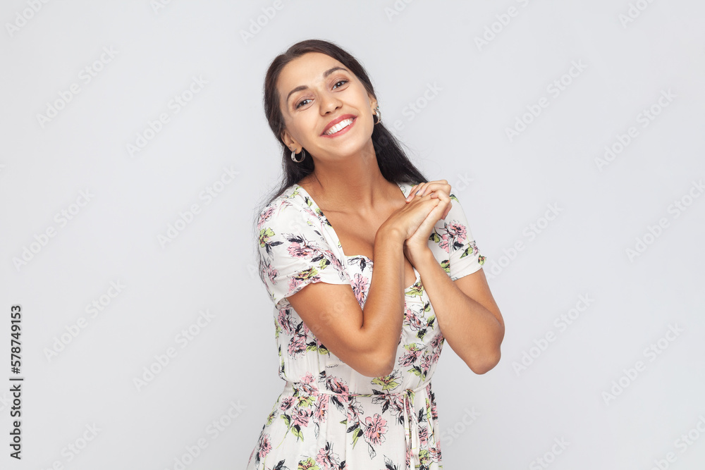 Cute charming beautiful woman looking at camera with toothy smile, keeps hands together, admires. Cute charming beautiful woman looking at camera with toothy smile, keeps hands together, admires.