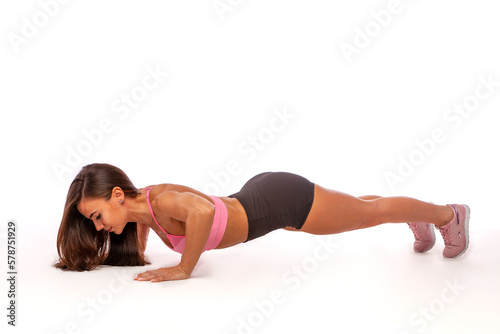 Close-up of a beautiful fitness girl in a sports top doing push-ups. Workout at home. Simple sports exercises for everyone © LoveSan