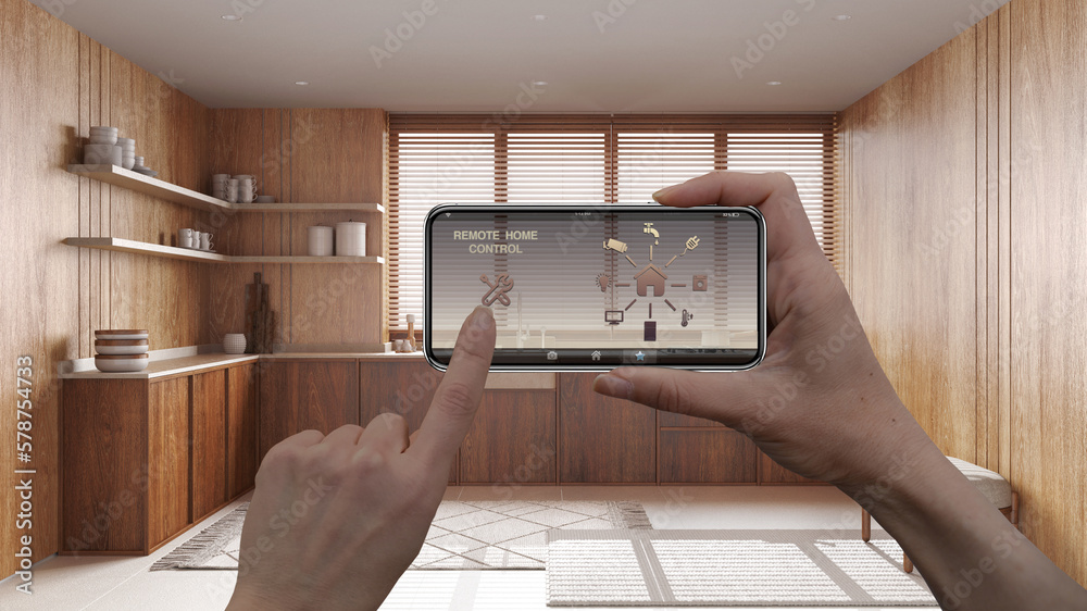 Remote home control system on a digital smart phone tablet. Device with app icons. Interior of japandi wooden kitchen in the background, architecture design Remote home control system on a digital smart phone tablet. Device with app icons. Interior of japandi wooden kitchen in the background, architecture design