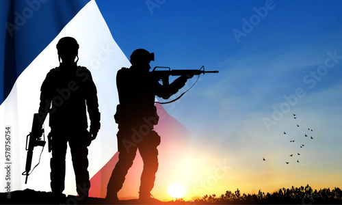 Silhouettes of French soldiers on background of sunset and French flag. Concept - Armed Forces. EPS10 vector