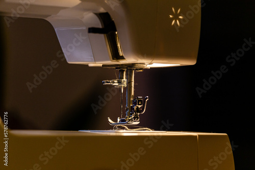 Leinwand Poster maquina de coser en penumbra con la luz de la maquina encendida