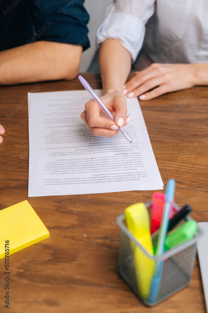 High-angle vertical cropped shot of unrecognizable businesswoman reading and signing contract or agreement sitting at table in office. Close up of business woman using pen signing on new contract. High-angle vertical cropped shot of unrecognizable businesswoman reading and signing contract or agreement sitting at table in office. Close up of business woman using pen signing on new contract.