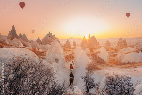 Landscape sunset in Cappadocia, travel tour excursion on horse with hot air balloons in Goreme Turkey