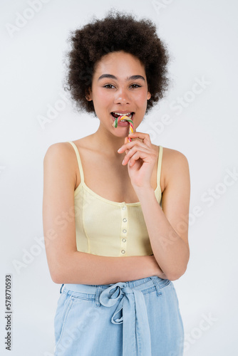 African american model holding colorful candy cane isolated on grey.