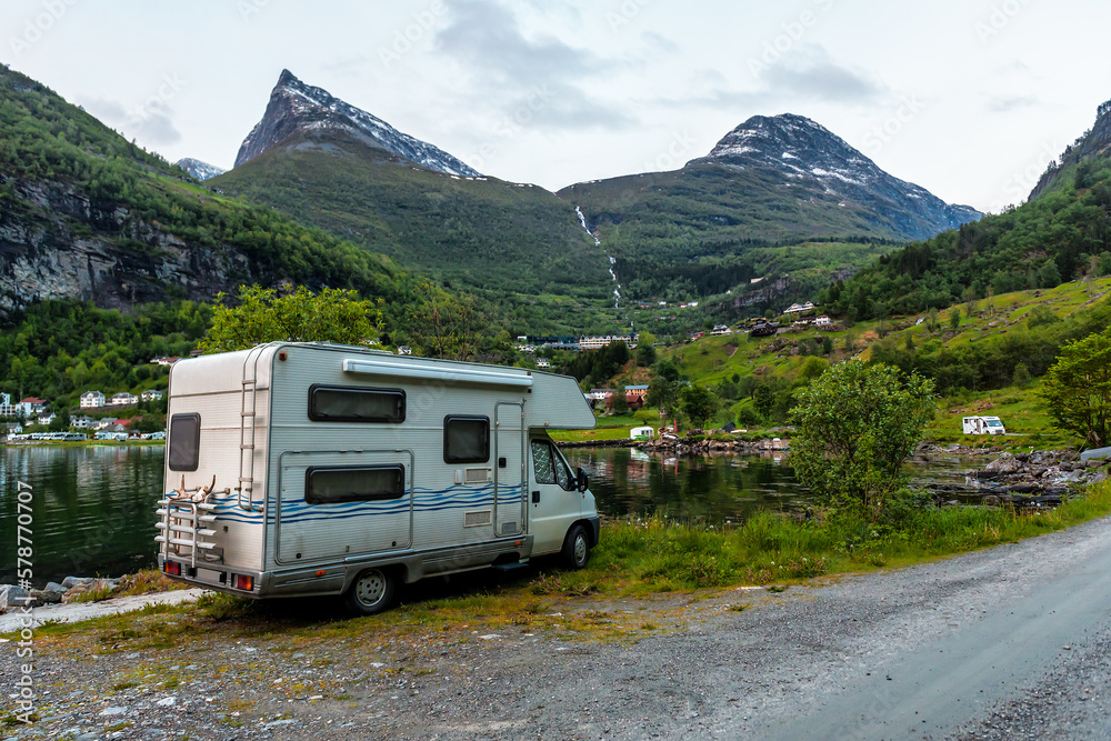Campervan on the shore of Geirangerfjord after sunset Campervan on the shore of Geirangerfjord after sunset