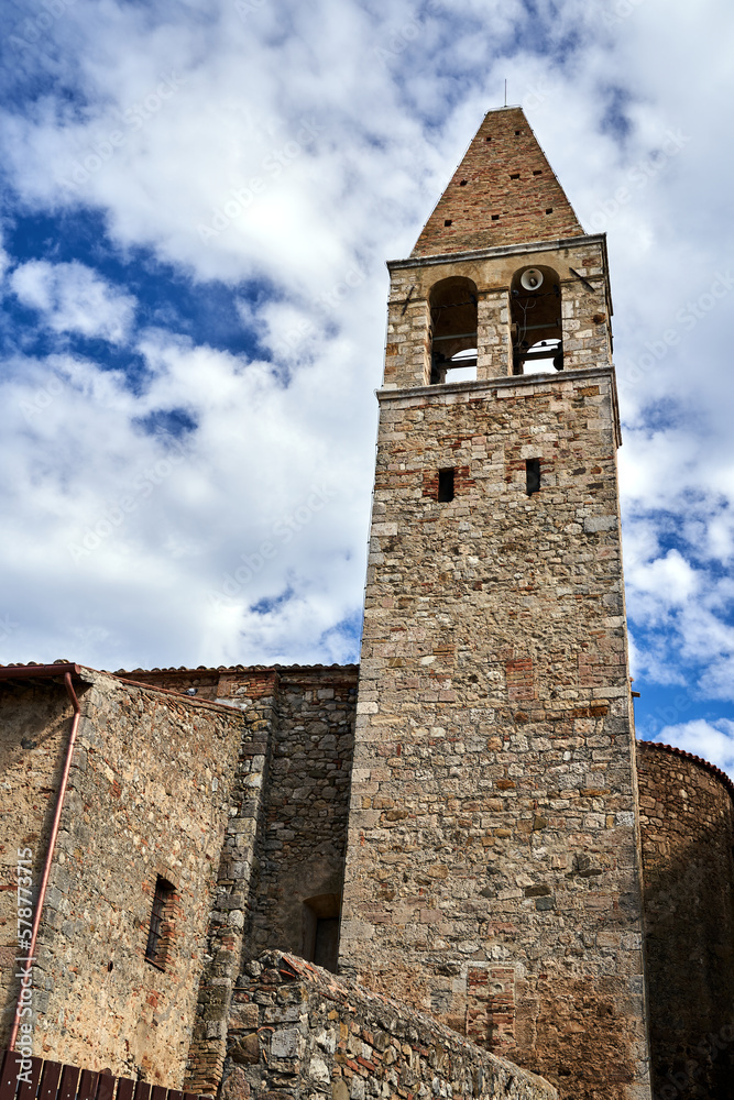 Historic church with a stone bell tower in the town of Magliano in Toscana