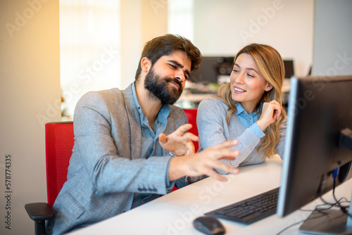 Confidence business man showing off while explaining project details to his beautiful female colleague on a meeting at office.