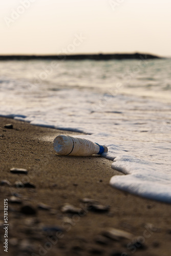 夕日に照らされて輝く沖縄の海と流れ着いたプラスチックごみ