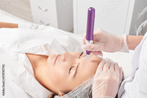 Beautician makes mesotherapy injection for rejuvenation woman face, anti aging non surgical cosmetic procedure in beauty salon. Cosmetologist hands in gloves makes facial micro needle injections
