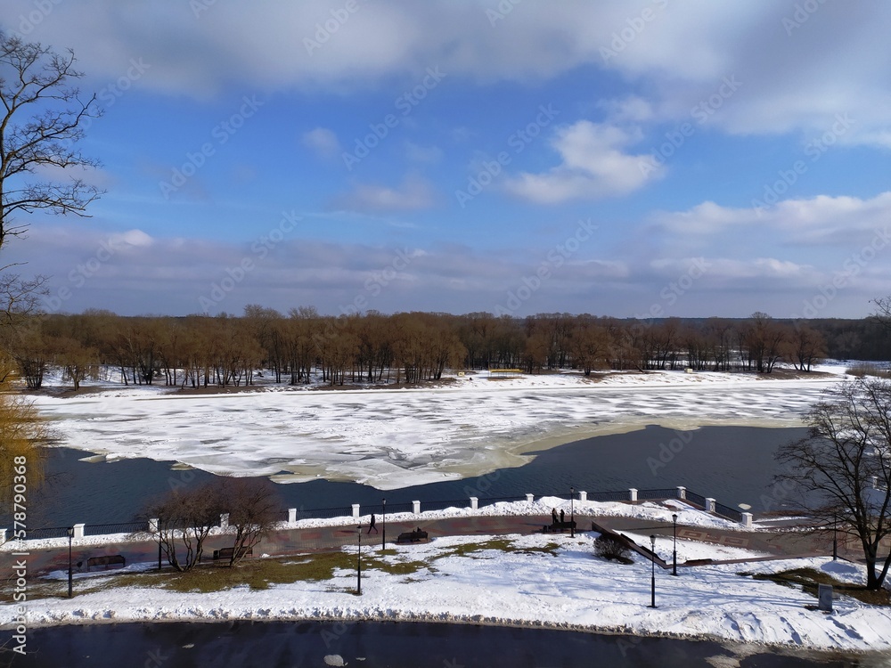 View of frozen lake in city park in early spring View of frozen lake in city park in early spring