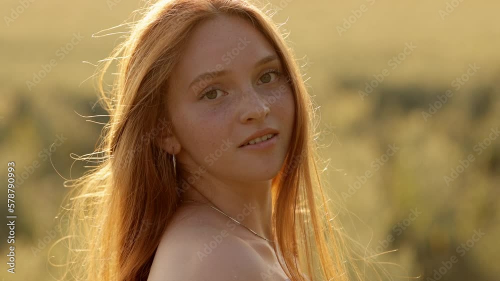 Portrait of a mysterious attractive beautiful girl with freckles enjoying nature in the field. Amazing red-haired woman touching her long hair and looking at the camera. Ukrainian girl. Portrait of a mysterious attractive beautiful girl with freckles enjoying nature in the field. Amazing red-haired woman touching her long hair and looking at the camera. Ukrainian girl.