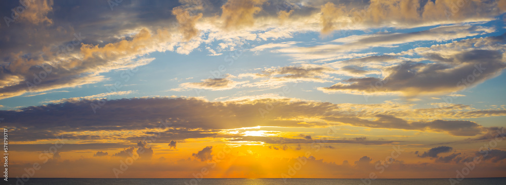 blue cloudy sky and low evenind sun, beautiful dramatic sunset background