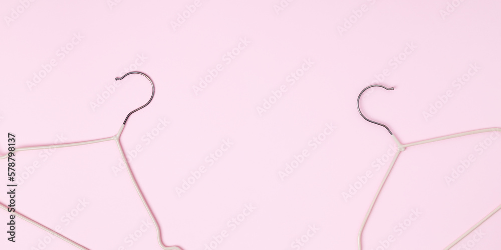 Creative flat lay hangers pastel pink background. Sale discount store promo shopping concept. Top view. Copy space