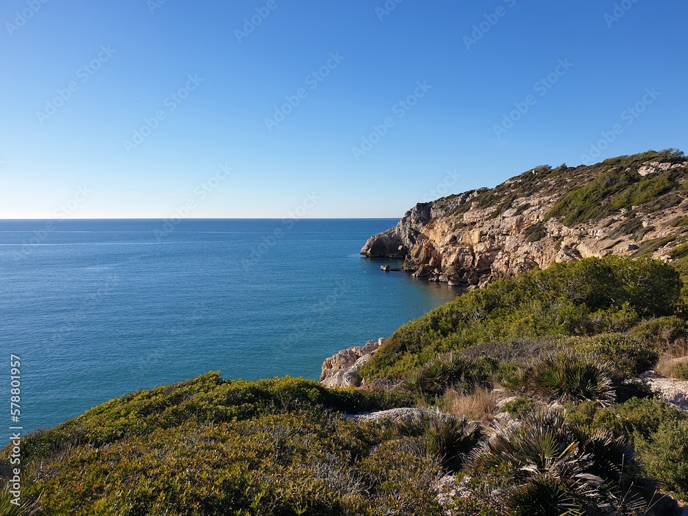 Rocky beach, coastline with turquoise sea, hiking in Sitges, Spain