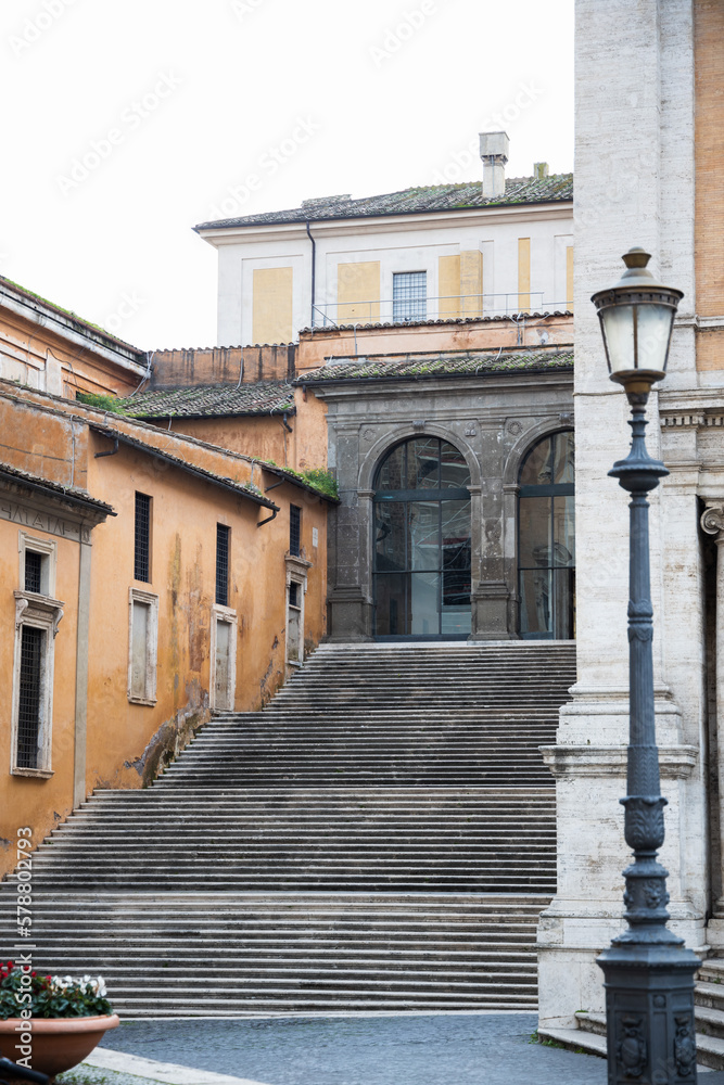 Stairs in Rome with ochre walls on the building, Steps near piazza Campidoglio