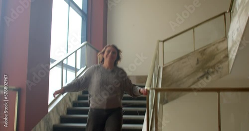 Happy adult woman jumps down the stairs after attending a psychotherapy session. Our inner child is the forgiving, free-spirited part of us that still feels and experiences life as a child. photo