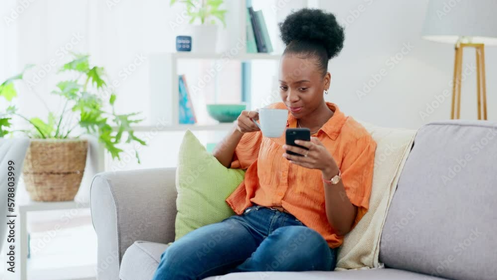 Phone, coffee and a black woman in the living room to relax while searching the internet for a meme. Social media, mobile and contact with a young female laughing at a text message on a sofa at home Phone, coffee and a black woman in the living room to relax while searching the internet for a meme. Social media, mobile and contact with a young female laughing at a text message on a sofa at home
