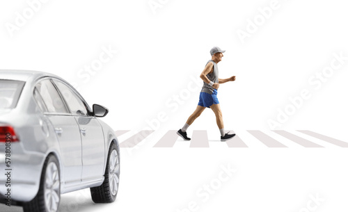 Mature male runner on a pedestrian crossing and a car waiting