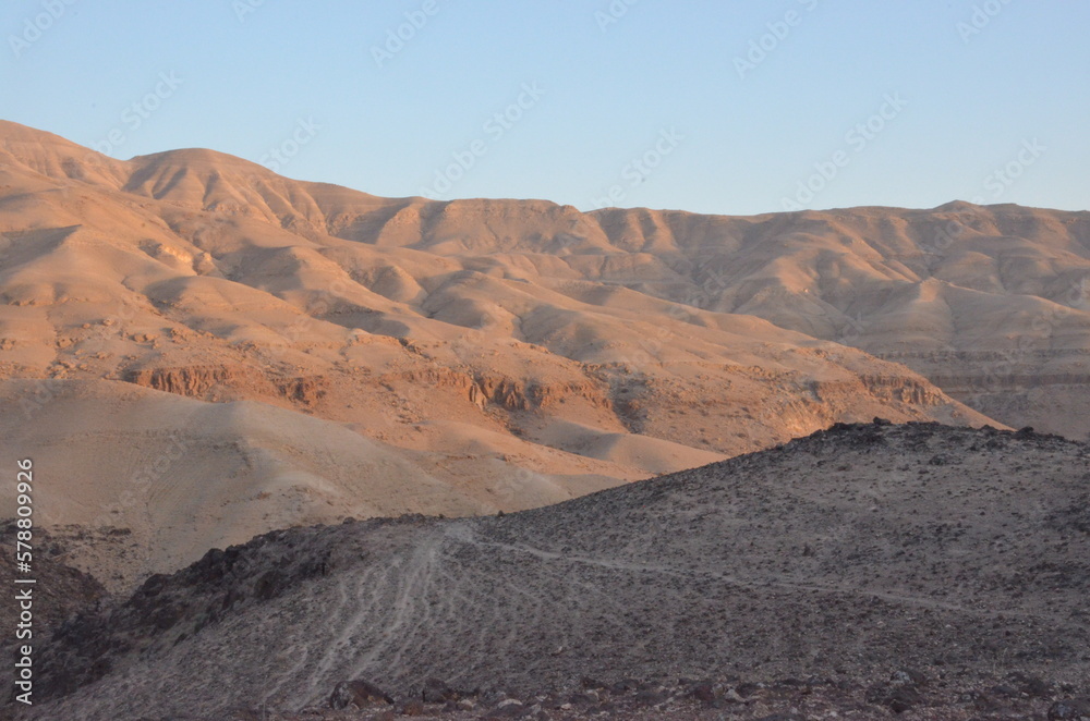 Naklejka premium Panoramic view of the rocks, canyons and the desert and dry landscape surrounding Madaba, Jordan, on a bright sunny day.