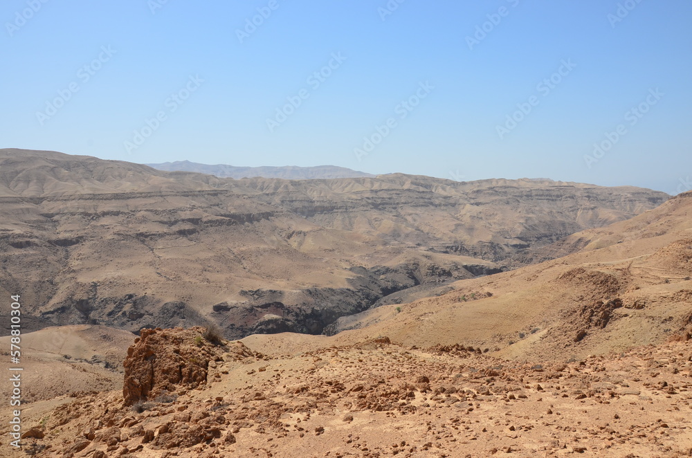 Panoramic view of the desert and dry landscape surrounding Madaba, Jordan, on a bright sunny day.