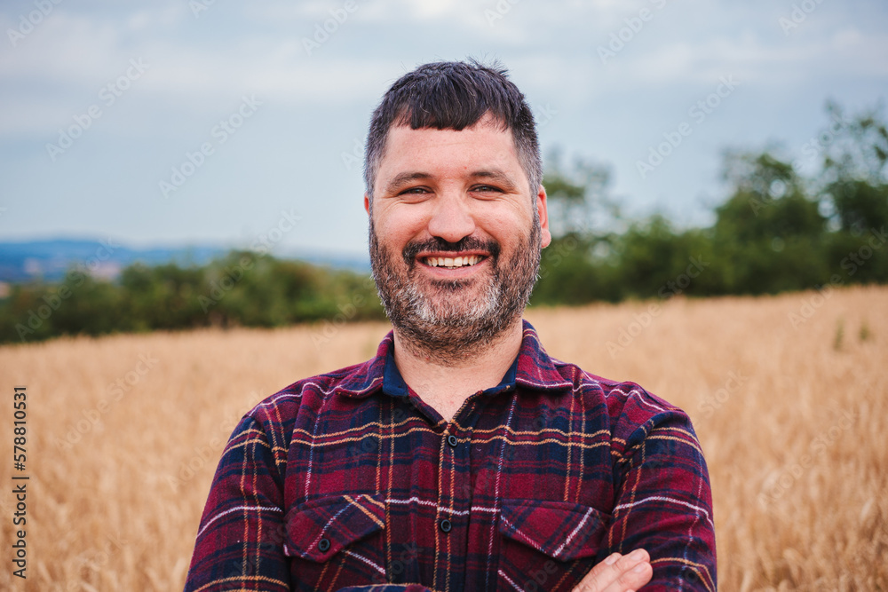 Close up portrait of one happy farmer man smiling and looking at camera with pride attitude at in a wheat field. Agricultural conept. High quality photo Close up portrait of one happy farmer man smiling and looking at camera with pride attitude at in a wheat field. Agricultural conept. High quality photo