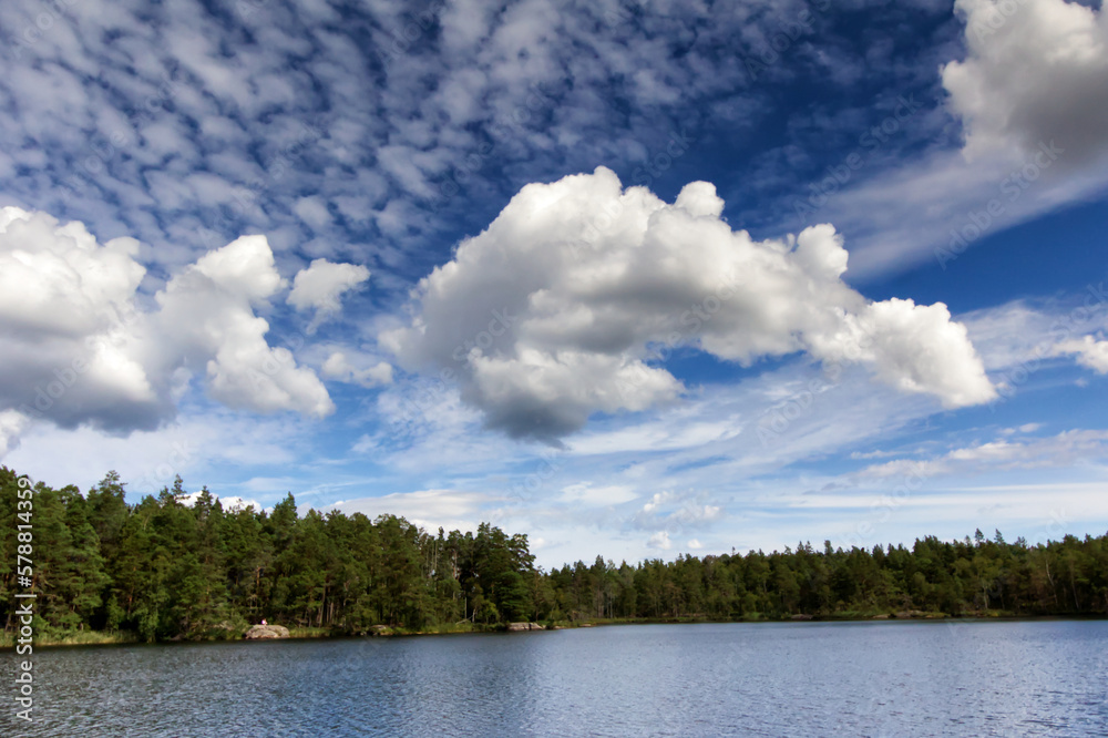 Different good weather clouds over a lake and forest in the Archipelago in Sweden