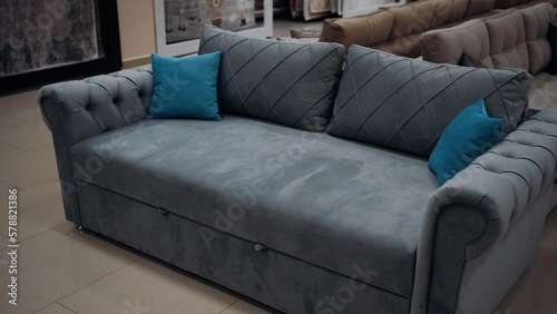 Gray sofa for two people with two blue decorative pillows. 4k video.