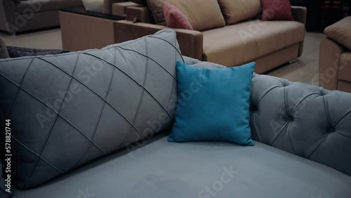 Zoom frame to a small blue pillow on a cozy gray couch. 4k video.