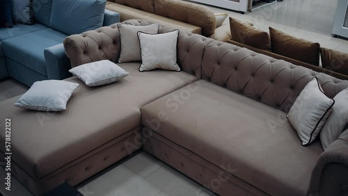 Top shot of a modern brown sofa with six white pillows arranged in a messy style. 4k video.