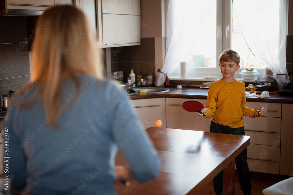 Young boy playing table tennis in the kitchen Young boy playing table tennis in the kitchen