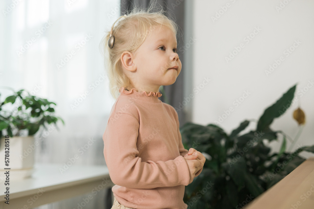 Deaf child girl with cochlear implant studying to hear sounds copy space - recovery after cochlear Implant surgery and rehabilitation concept Deaf child girl with cochlear implant studying to hear sounds copy space - recovery after cochlear Implant surgery and rehabilitation concept
