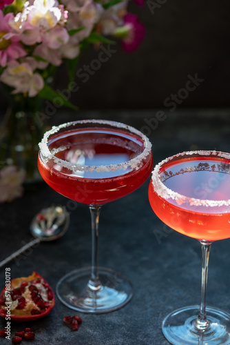 Two glasses with red pomegranate cocktail. Party, mixed colourful cocktail. Dark background