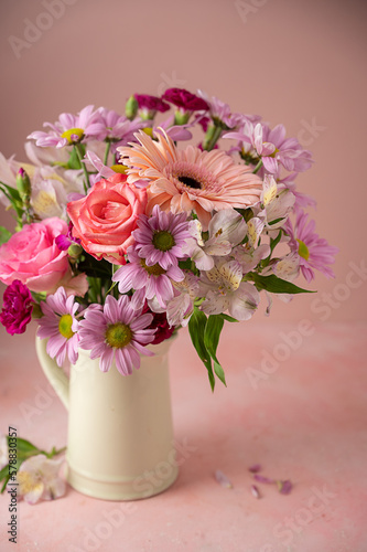 Beautiful fresh spring flowers. Pink bouquet of flowers in vase  on pink background.