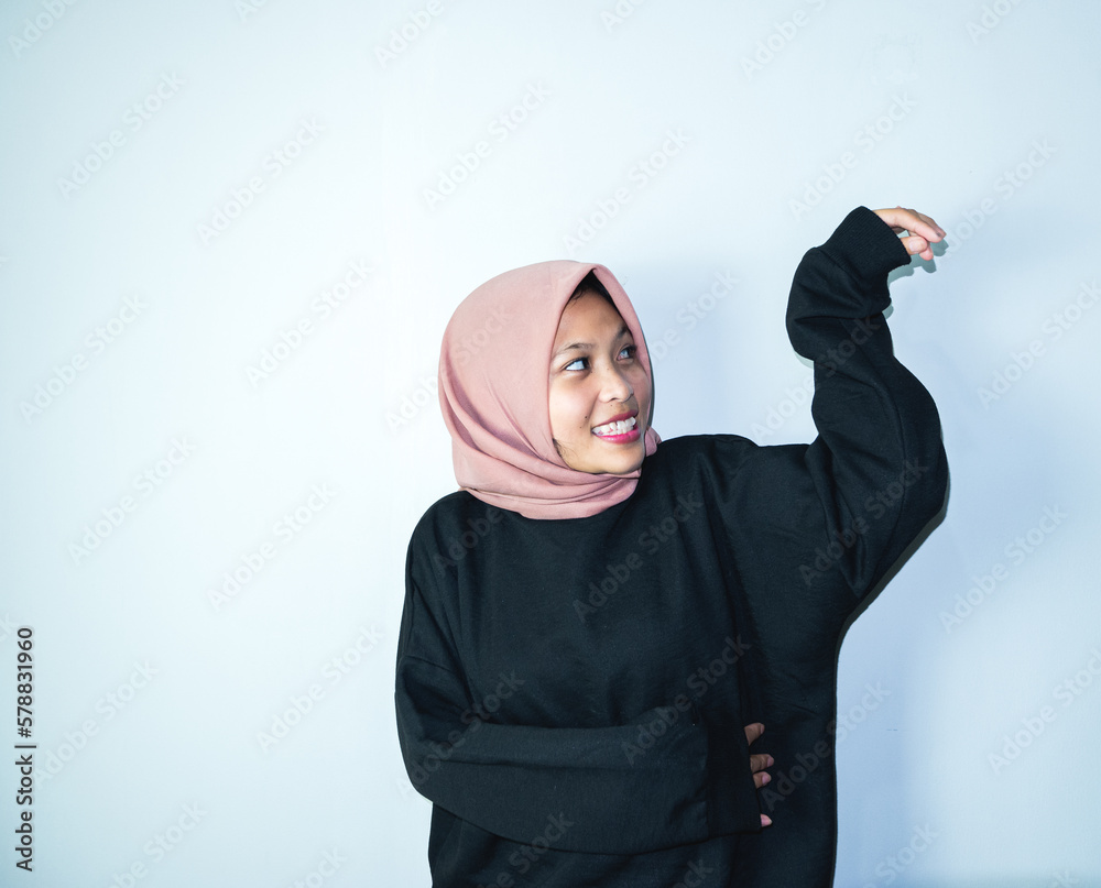 Beautiful smiling Asian woman looking confident isolated over light grey background. ramadhan concept Beautiful smiling Asian woman looking confident isolated over light grey background. ramadhan concept