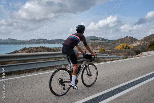 Man cyclist wearing cycling kit and helmet.Man riding on bicycle in the mountains.Male cyclist is riding on bicycle in the mountains.Serra de Bèrnia,Alicante, Spain