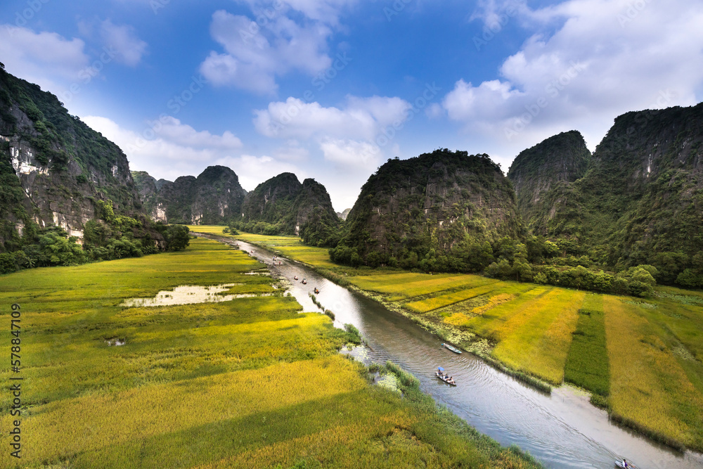 The boats carry tourists through the caves and rice fields on the Ngo Dong river at Tam Coc-Bich Dong area, a famous tourist destination in Ninh Binh province, Vietnam