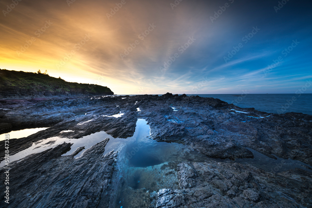 Obraz premium Beautiful sunset on the evening sea in Quang Nam province, Vietnam, volcanic rocks in the foreground