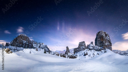 Starry night over the Cinque Torri on a snowy winter landscape in Cortina d'Ampezzo, Italy photo