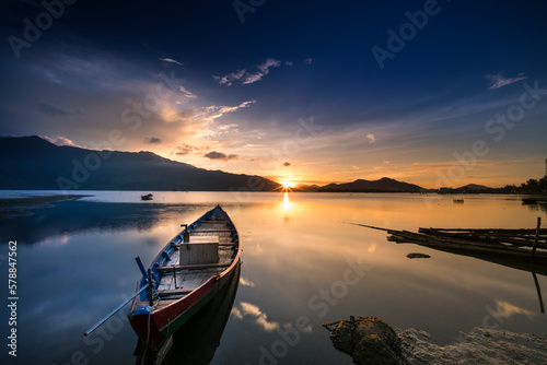 Beautiful sunset at the lagoon with the boat the main focus. The concept of lonely feeling