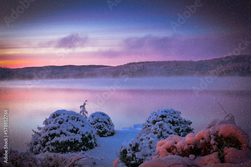 cold morning sunrise on a lake after a snowstorm with snowflakes, Quebec, Canada -  copy space