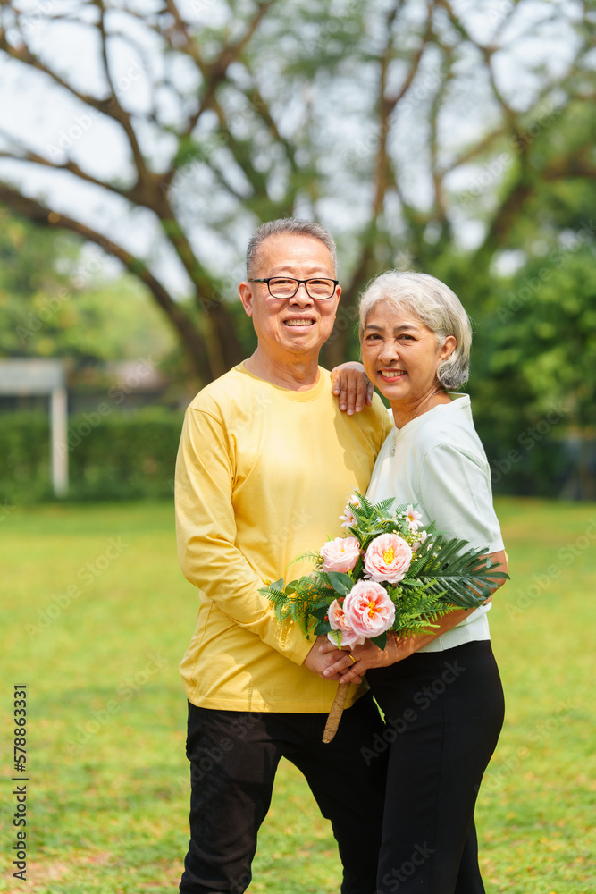 Never stop loving each other, Asian people elderly husband and wife relaxing in park outdoor in springtime.